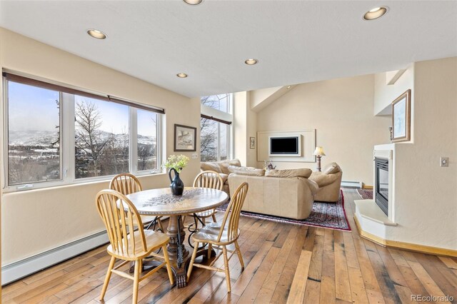 11 Hackamore Rd Unit B, Edwards, CO 81632 - dining space with a glass covered fireplace, a baseboard heating unit, hardwood / wood-style floors, and recessed lighting