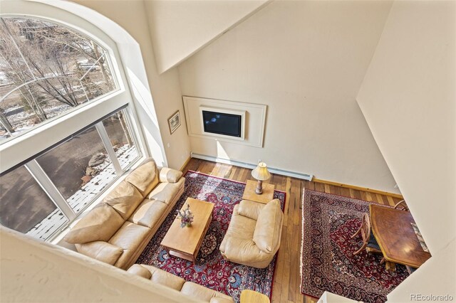 11 Hackamore Rd Unit B, Edwards, CO 81632 - living room featuring wood-type flooring, baseboard heating, and a high ceiling