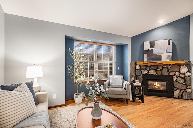 living area featuring wood finished floors, a fireplace, and baseboards