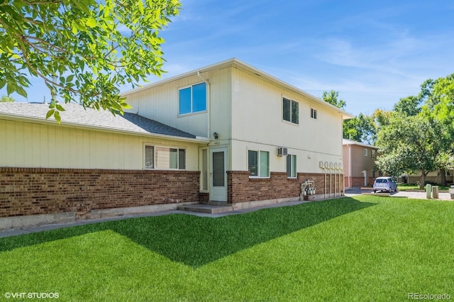 rear view of property featuring a lawn