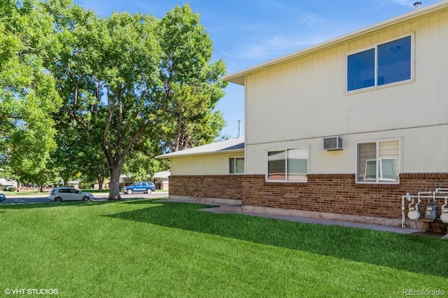 view of side of home featuring a wall mounted air conditioner and a yard