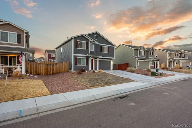 traditional home featuring a garage, a residential view, fence, and driveway