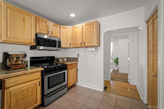 502 E San Miguel St, Colorado Springs, CO 80903 - kitchen with stainless steel microwave, range with gas cooktop, light tile patterned flooring, light brown cabinetry, and recessed lighting