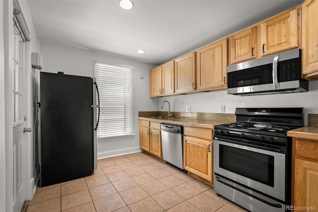 502 E San Miguel St, Colorado Springs, CO 80903 - kitchen with stainless steel appliances, light tile patterned flooring, light brown cabinetry, and recessed lighting