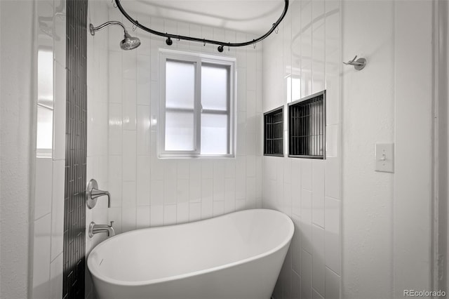502 E San Miguel St, Colorado Springs, CO 80903 - full bathroom featuring a soaking tub, a shower, and tile walls