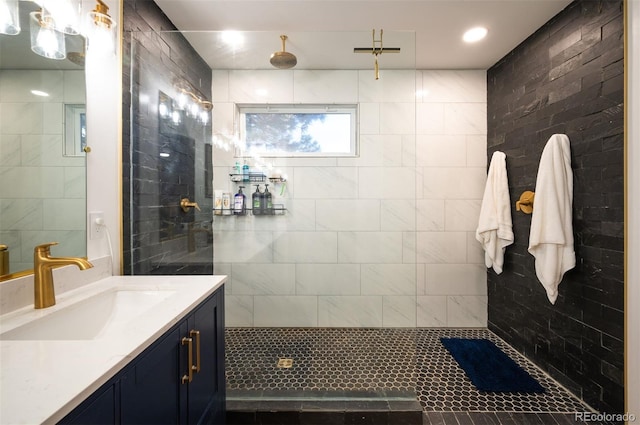 bathroom featuring tiled shower and vanity