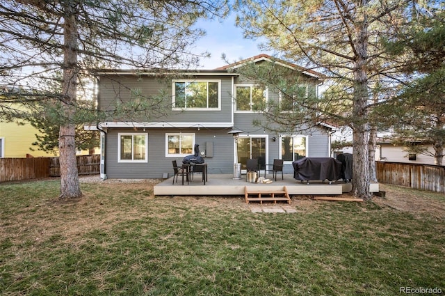 back of property featuring a wooden deck and a yard