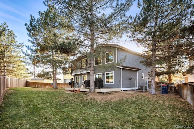 rear view of property featuring cooling unit, a yard, and a wooden deck