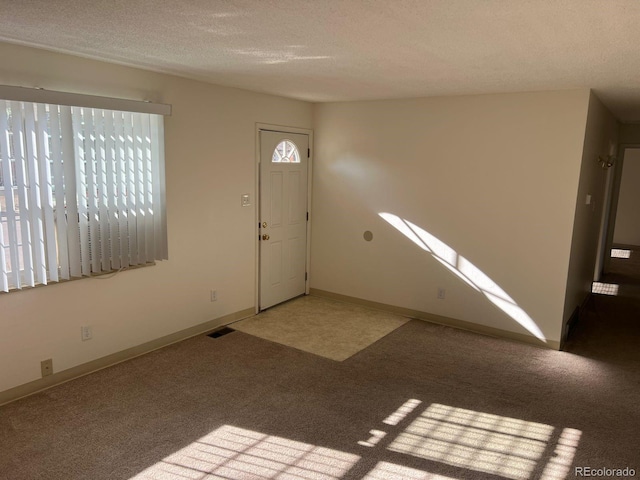 5543 Victor St, Denver, CO 80239 - carpeted entryway featuring a textured ceiling and baseboards