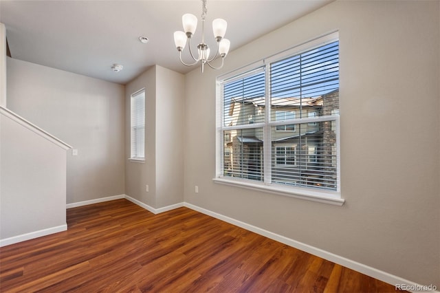 unfurnished room featuring hardwood / wood-style floors and a chandelier