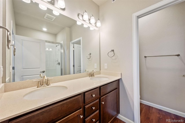 bathroom featuring hardwood / wood-style floors, vanity, and walk in shower