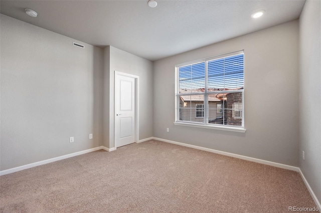 spare room featuring light carpet