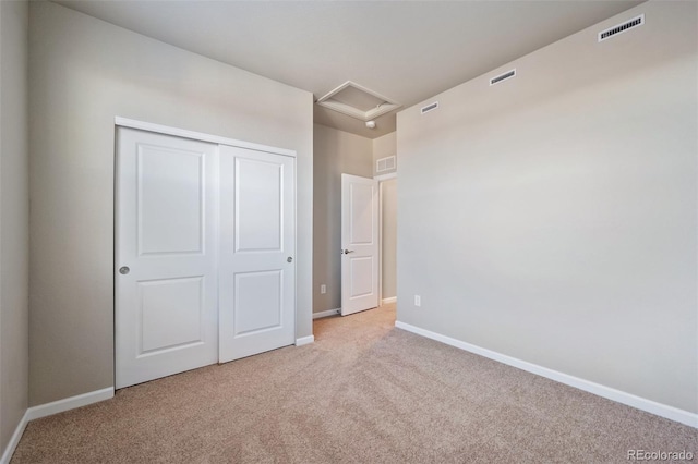 unfurnished bedroom featuring light colored carpet and a closet