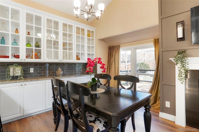 dining room with light wood-type flooring and a chandelier