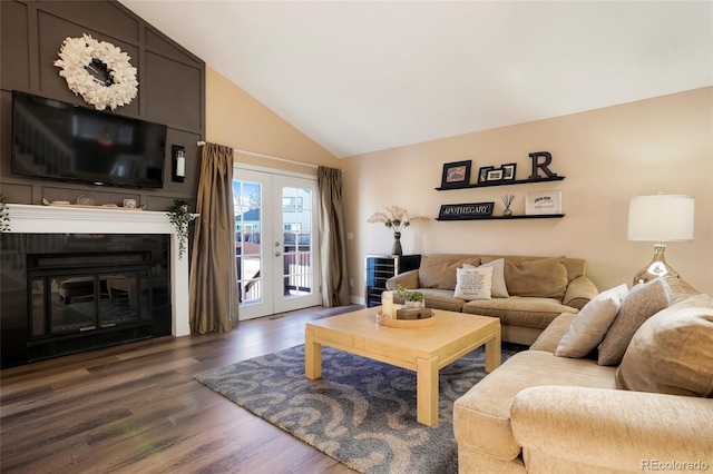 living area with lofted ceiling, french doors, a glass covered fireplace, and dark wood finished floors