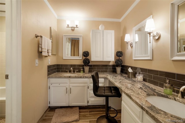 full bathroom featuring a washtub, tasteful backsplash, ornamental molding, vanity, and wood finished floors