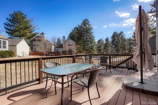 wooden terrace featuring outdoor dining area and a residential view