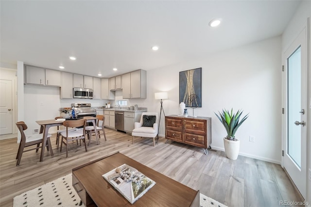 46542 Avery Ln, Bennett, CO 80102 - living area with light wood-style flooring, recessed lighting, baseboards, and healthy amount of natural light