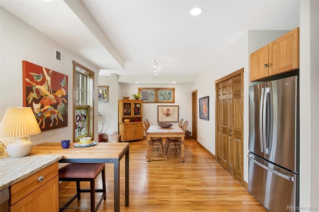 interior space with visible vents, freestanding refrigerator, light stone countertops, light wood-type flooring, and recessed lighting
