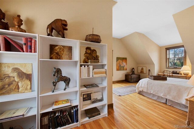 bedroom featuring wood finished floors and vaulted ceiling