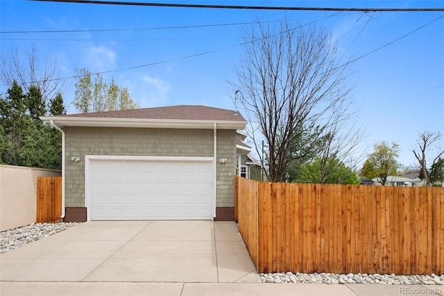 view of side of home featuring fence and a garage