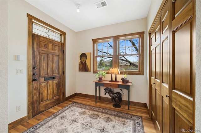 entrance foyer featuring baseboards, light wood-type flooring, and visible vents