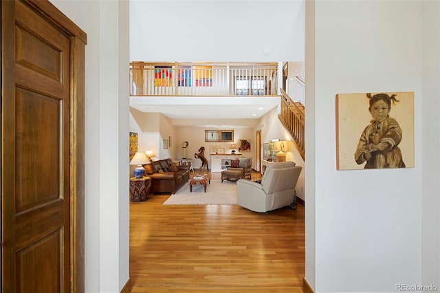 living room featuring light wood-type flooring and a high ceiling