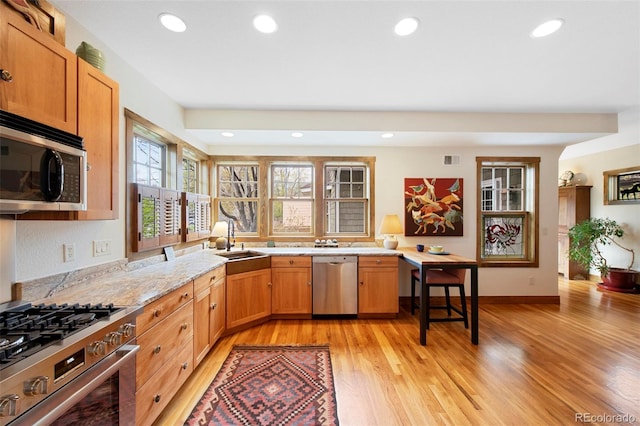 kitchen featuring visible vents, appliances with stainless steel finishes, a sink, light wood finished floors, and recessed lighting
