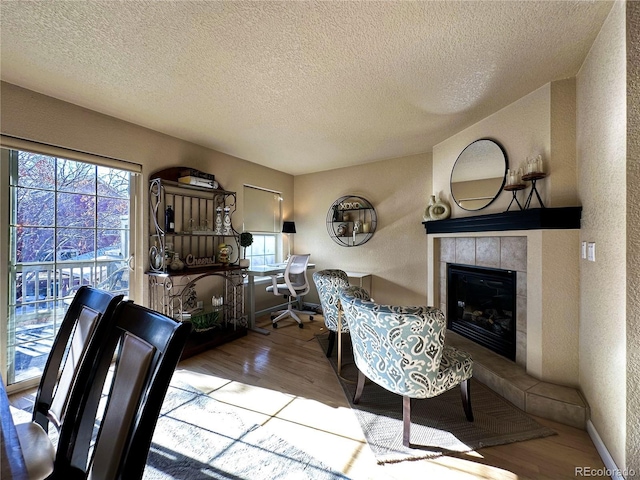 interior space featuring a fireplace, a textured ceiling, and light hardwood / wood-style floors