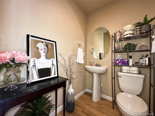 bathroom featuring hardwood / wood-style floors and toilet