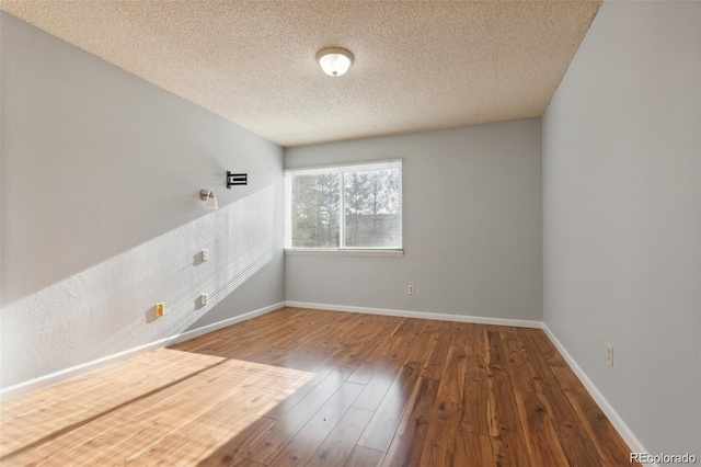 unfurnished room featuring wood-type flooring and a textured ceiling