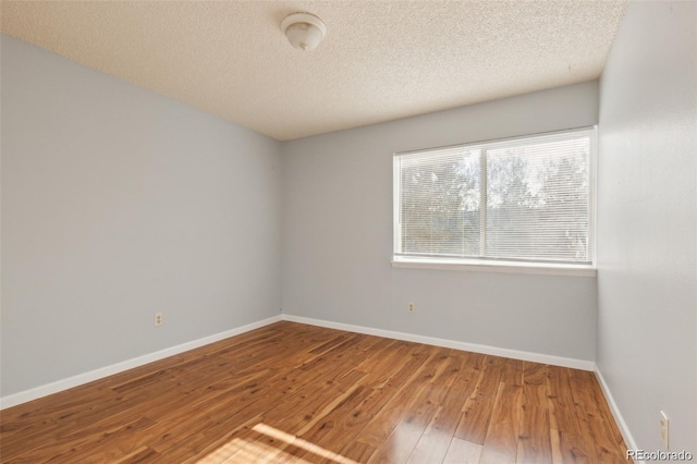 empty room featuring hardwood / wood-style floors and a textured ceiling