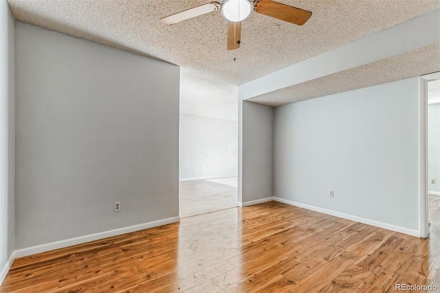 empty room featuring ceiling fan, hardwood / wood-style flooring, and a textured ceiling