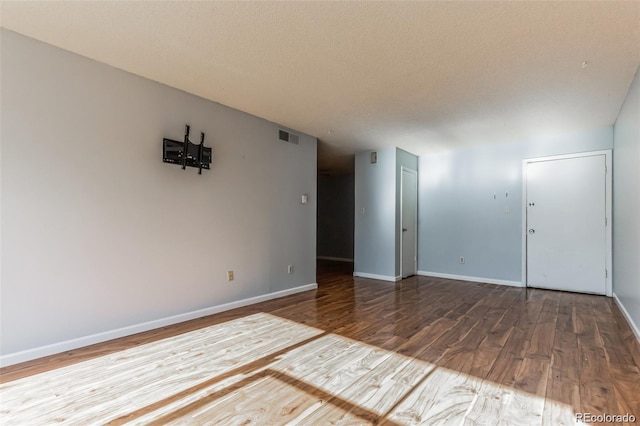 unfurnished room featuring hardwood / wood-style floors and a textured ceiling