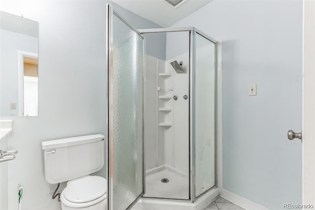 bathroom featuring tile patterned floors, toilet, and a shower with door