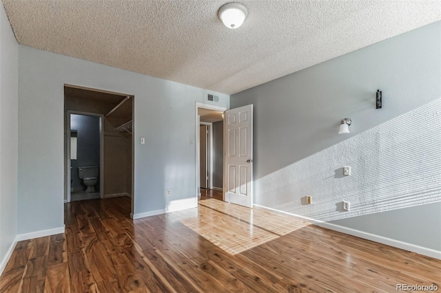 empty room featuring dark hardwood / wood-style floors and a textured ceiling