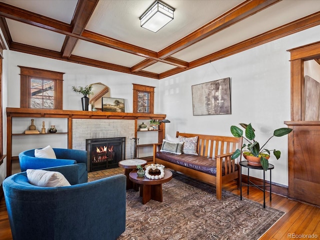 living room featuring hardwood / wood-style flooring, a fireplace, coffered ceiling, and beam ceiling