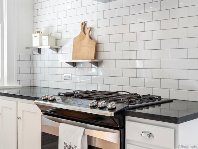 kitchen with open shelves, dark countertops, decorative backsplash, gas stove, and white cabinetry