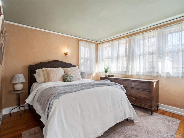 bedroom featuring wood finished floors and baseboards