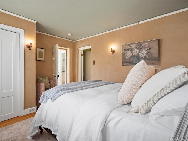 bedroom with baseboards, ornamental molding, and wood finished floors