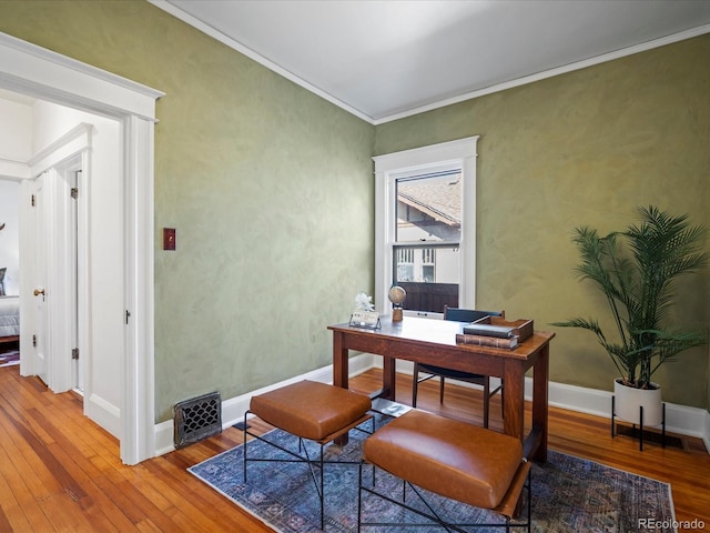 office space featuring wood-type flooring, crown molding, and baseboards