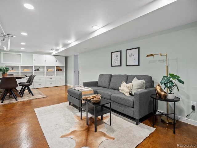 living room with concrete flooring, recessed lighting, and baseboards