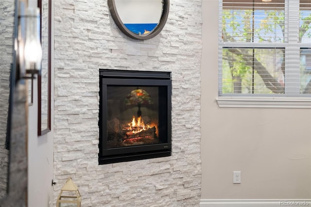 room details with a stone fireplace and baseboards