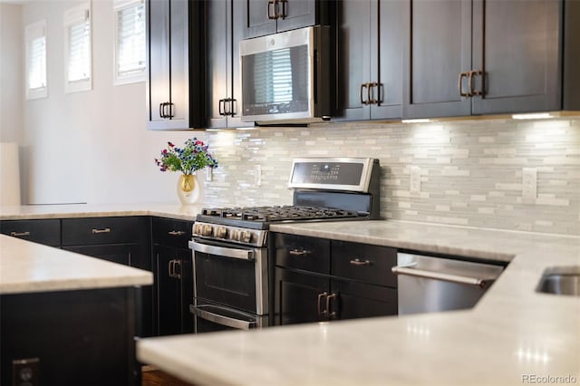 kitchen featuring light countertops, stainless steel appliances, and backsplash