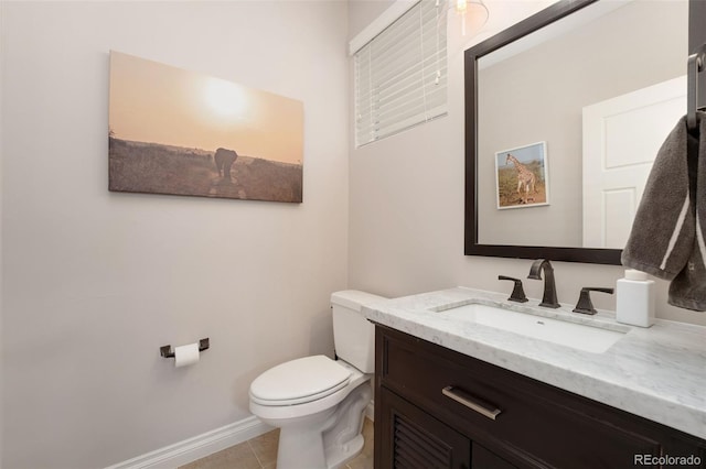 half bathroom with toilet, baseboards, tile patterned flooring, and vanity