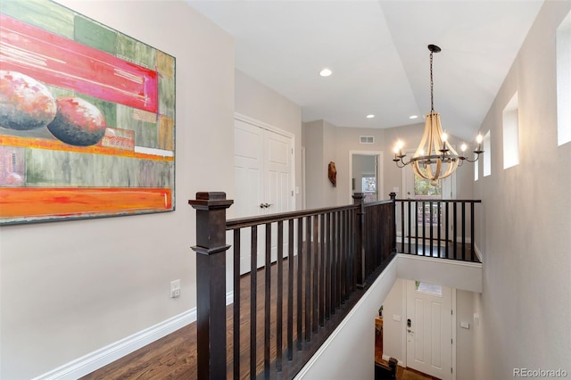 staircase with an inviting chandelier, visible vents, wood finished floors, baseboards, and recessed lighting