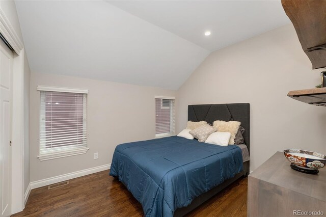 bedroom with visible vents, baseboards, lofted ceiling, and wood finished floors
