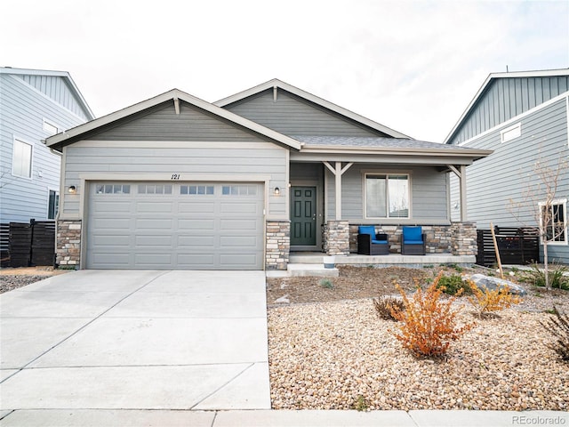 craftsman house featuring a porch, driveway, fence, an attached garage, and stone siding