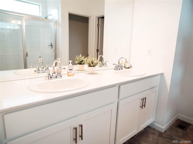 bathroom featuring double vanity, a sink, and a shower stall