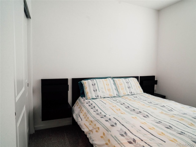 bedroom featuring dark carpet and a closet